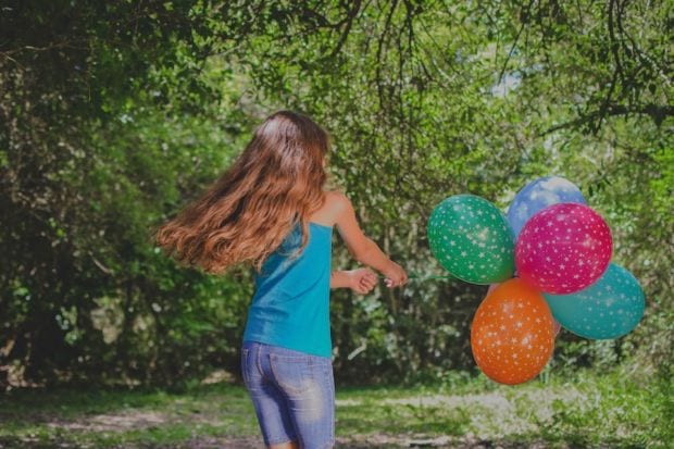 Mädchen mit Luftballons im Garten