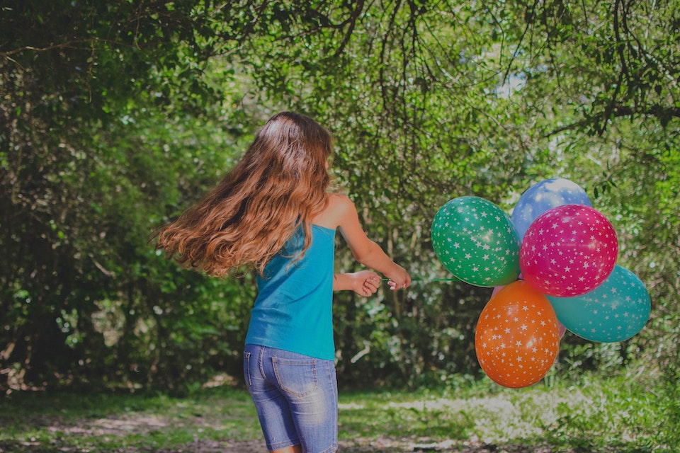 Mädchen mit Luftballons im Garten